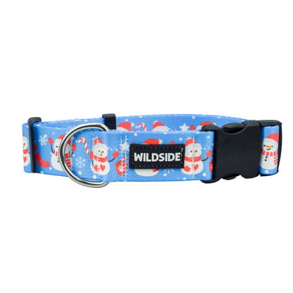 A blue dog collar with a Christmas-themed pattern featuring snowmen and the brand name 'wildside' on a tag.